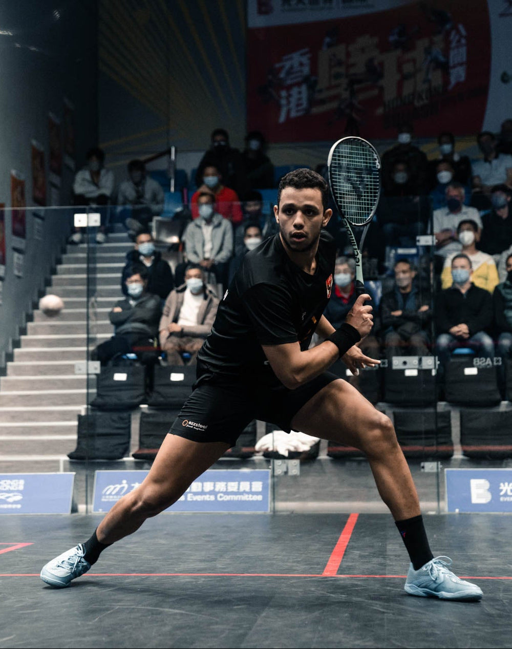 Squash athlete rallying inside glass court
